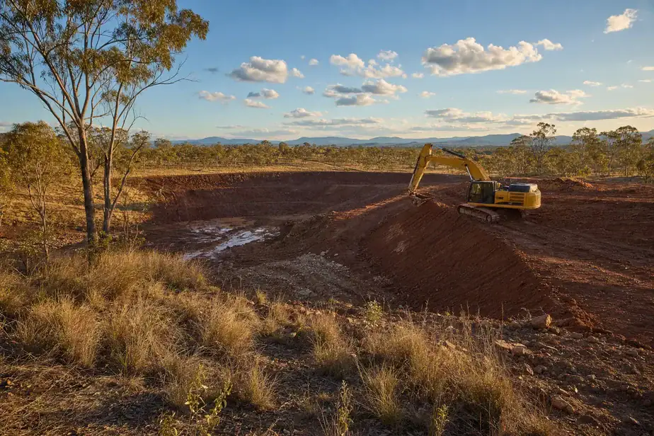 Excavator working on land development for aquatic architecture project.