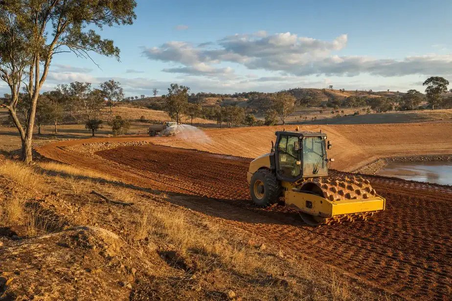 Heavy machinery working on land development in rural landscape.