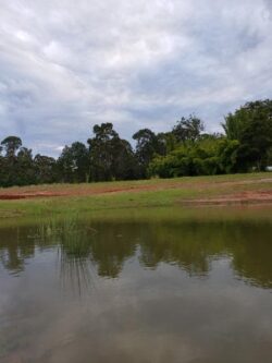 Heavy dam construction site with earthworks near waterbody, promoting Big Ditch Dam Building expertise.