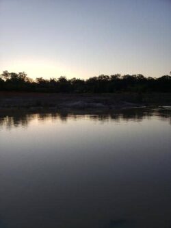 Dam construction site at Big Ditch Dam Building Company, showcasing water and landscape.