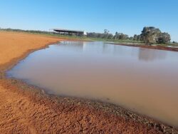 - Dam construction site by Big Ditch Dam Building Company with water reservoir and construction equipment.