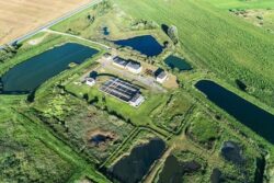 Large dam infrastructure with water reservoirs and green surroundings, showcasing water management solutions.