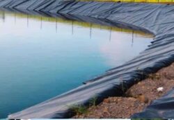 Freshwater dam construction with black geomembrane lining by Big Ditch Dam Building Company.
