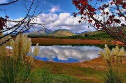 Serene dam construction site with mountains and clear water, expert dam building services in Australia.