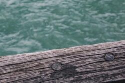 Rough wooden dam structure with water in the background, showcasing quality dam building craftsmanship.